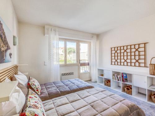 une chambre avec un grand lit et une fenêtre dans l'établissement Apartment Les Mimosas by Interhome, à Sainte-Maxime
