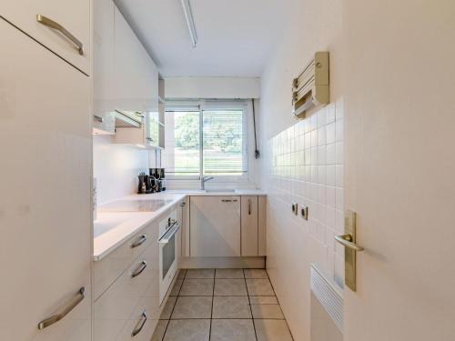une cuisine blanche avec un évier et une fenêtre dans l'établissement Apartment Les Côteaux du Préconil-3 by Interhome, à Sainte-Maxime