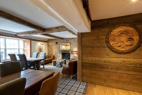 a room with a wooden wall with a table and chairs at The Greyhound Hotel in Shap