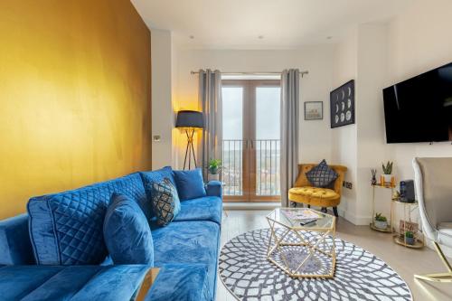 a living room with a blue couch and a tv at LillyRose Serviced Apartments - St Albans City Centre, Parking in St. Albans