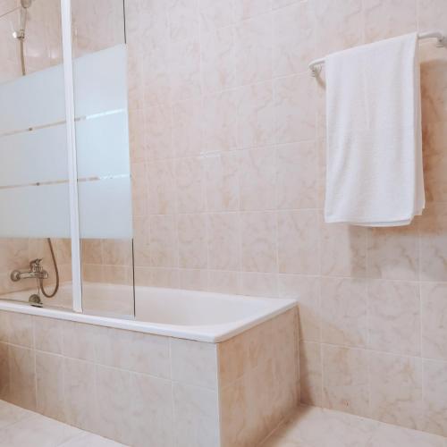 a bathroom with a shower with a tub and a towel at O Palheiro in Bragança