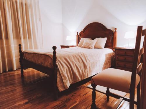 a bedroom with a bed and a dresser and a chair at O Palheiro in Bragança