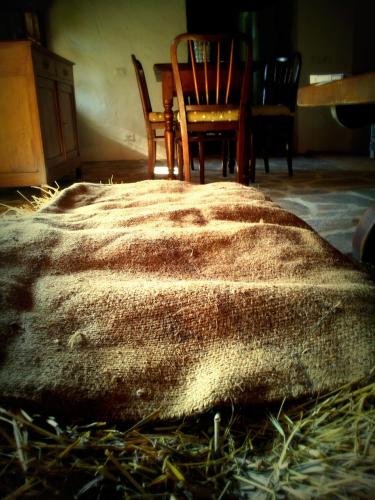 a blanket on the floor with a chair and a table at Navilla in Igliano