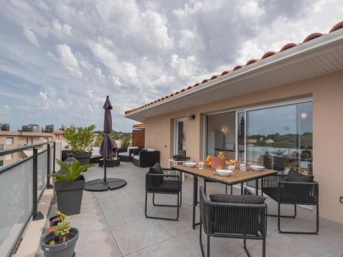 eine Terrasse mit einem Tisch und Stühlen auf dem Dach in der Unterkunft Apartment Eden Riviera by Interhome in Cavalaire-sur-Mer