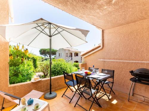 um pátio com uma mesa e um guarda-chuva em Apartment Les Coteaux de la Nartelle-26 by Interhome em Sainte-Maxime