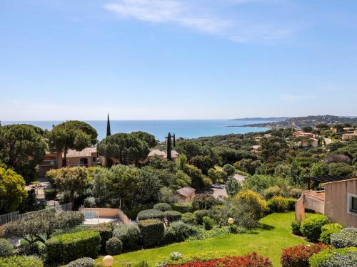 uma vista para um jardim com o oceano ao fundo em Apartment Les Coteaux de la Nartelle-26 by Interhome em Sainte-Maxime