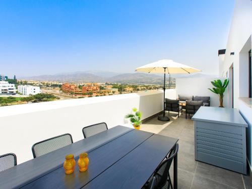 ein Esszimmer mit einem Tisch und einem Sonnenschirm in der Unterkunft Apartment Piscis by Interhome in Torre del Mar