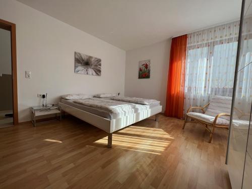 1 dormitorio con 1 cama y 1 silla en Haus Lauria, en Kressbronn am Bodensee