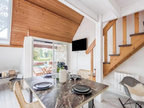 une salle à manger avec une table et un escalier dans l'établissement Apartment Les Druides-2 by Interhome, à Carnac