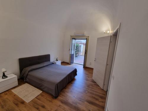 Un dormitorio con una cama y una puerta a un pasillo. en Palazzo Mannino Apartments, en Catania