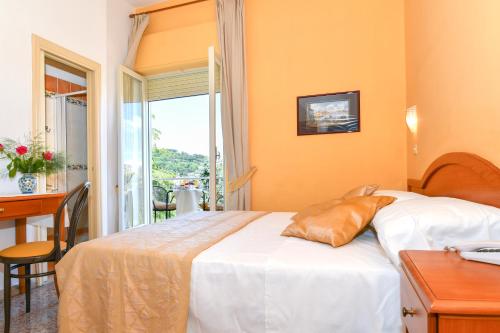 Pokój hotelowy z łóżkiem, biurkiem i oknem w obiekcie Hotel Villa Fernanda w mieście Massa Lubrense