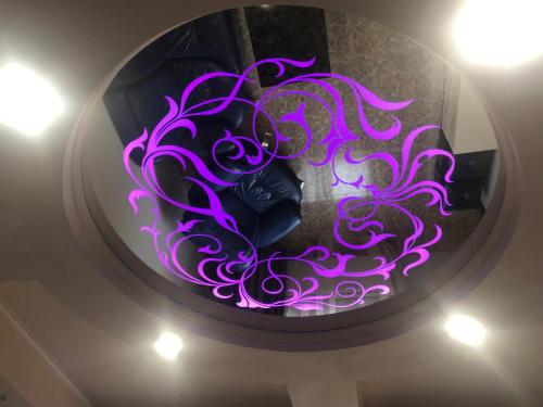 a purple neon sign on a ceiling with lights at Ashtarak-1 Modern Apartment in Ashtarak
