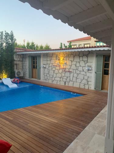 einen Hinterhof mit einem Pool und einer Steinmauer in der Unterkunft My Dream Alaçatı in Alacati