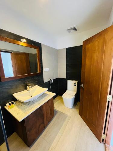 a bathroom with a sink and a toilet at Bayfront in Weligama