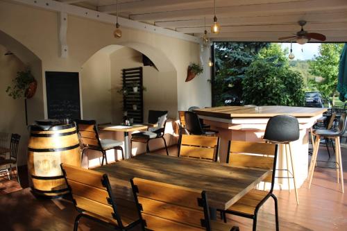 ein Restaurant mit Holztischen und -stühlen und einer Bar in der Unterkunft Taverna 1860 Rooms & Apartments in Donja Zelina