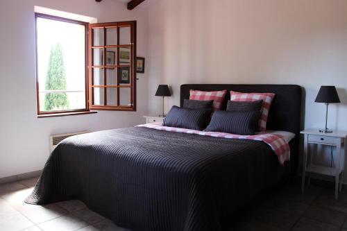 a bedroom with a black bed with a window at Villa Golf Azur in Saint-Raphaël