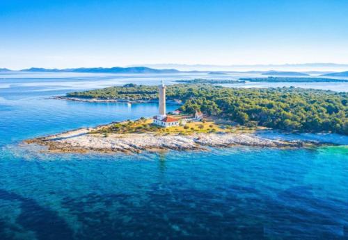 an island in the water with a lighthouse on it at Veli Rat Lighthouse in Veli Rat