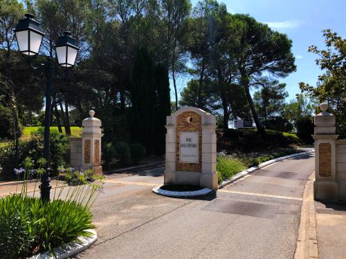 a gate in a street with a street light and trees at Villa Golf Azur in Saint-Raphaël