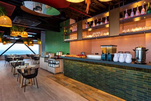 a restaurant with a bar with tables and chairs at Sea Avenue Hotel in San Andrés