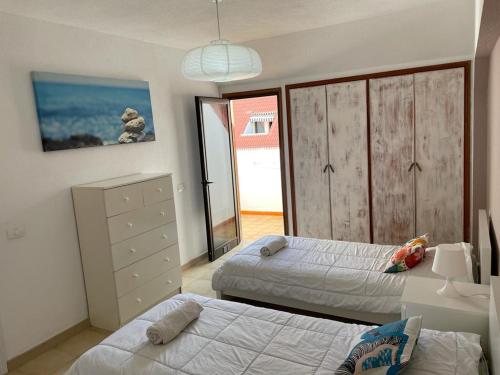 a bedroom with two beds and a large window at Duplex Las Americas in Playa de las Americas