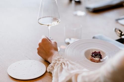 a person sitting at a table with a plate and a wine glass at Casa di Langa in Cerretto Langhe