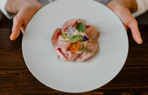 a person holding a white plate with food on it at Casa di Langa in Cerretto Langhe