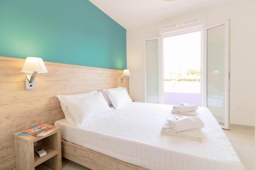 - une chambre avec un grand lit blanc et une fenêtre dans l'établissement SELECT'SO HOME - Résidence Le Poséidon - Mazet en Duplex - Prestations de qualité & Services Hôteliers - POS-D, à Bormes-les-Mimosas