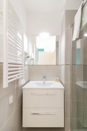 une salle de bain blanche avec un lavabo et un miroir dans l'établissement SELECT'SO HOME - Résidence Le Poséidon - Mazet en Duplex - Prestations de qualité & Services Hôteliers - POS-D, à Bormes-les-Mimosas