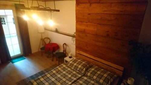 ein Schlafzimmer mit einem Bett und einer Holzwand in der Unterkunft kajakshop-wildalpen in Wildalpen