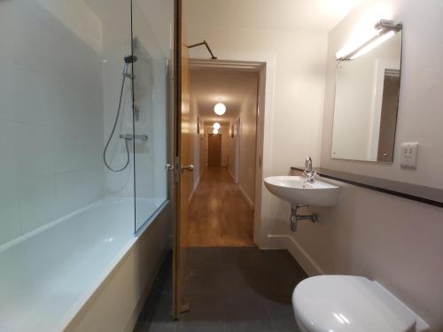 uma casa de banho com um chuveiro, um WC e um lavatório. em Moat House - Highland Club em Fort Augustus