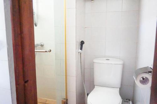 a bathroom with a toilet and a shower with a hose at Club Bentota in Bentota