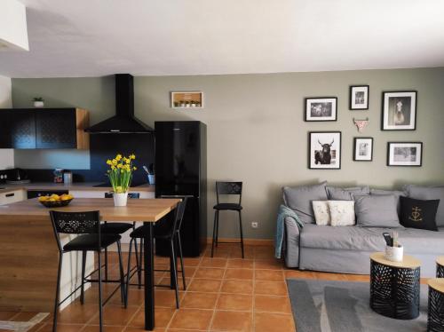 une cuisine et un salon avec un canapé et une table dans l'établissement Maison de vacances dans Résidence avec Piscine, à Arles