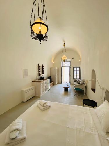 a large white room with a bed and a living room at Ikia Kriton in Imerovigli