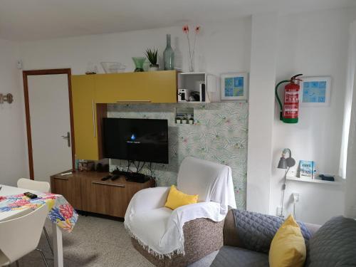a living room with a tv and a white chair at Casa Mary in Granadilla de Abona