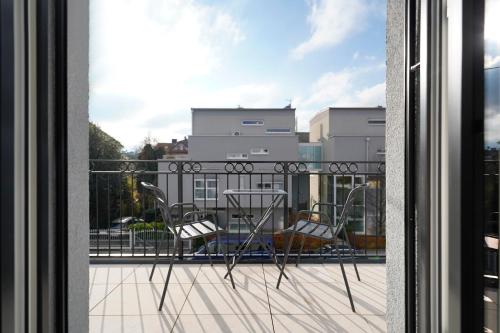 Habitación con vistas a un balcón con mesa y sillas. en numa I Maximilian, en Salzburgo