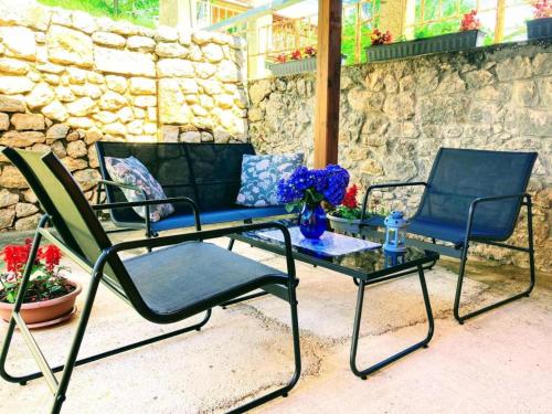 two chairs and a table and a couch on a patio at Apartman Sara in Grižane