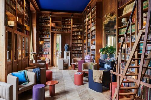 a library with chairs and bookshelves at Maison du Val - Les Maisons de Campagne in Saint-Germain-en-Laye