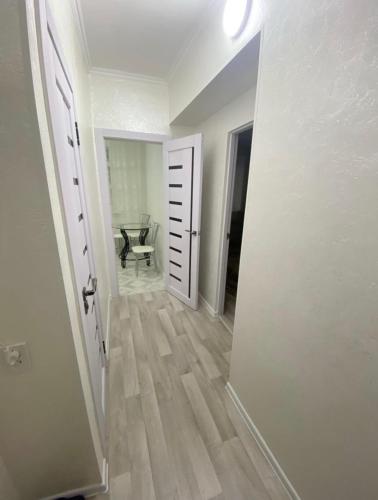 un couloir avec une porte ouverte et une chaise dans une chambre dans l'établissement Ахметова 6 7, à Almaty