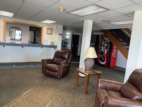 a lobby with two chairs and a table and a soda machine at Travelodge by Wyndham Green River UT in Green River