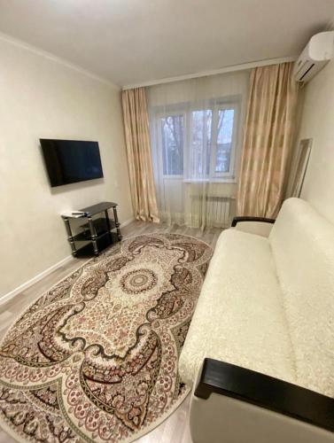 a hotel room with a bed and a rug at Ахметова 6 7 in Almaty