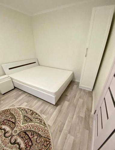 a small room with a bed and a rug at Ахметова 6 7 in Almaty