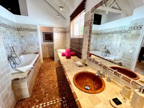 a large bathroom with two sinks and a tub and a tub at Villa Privilege in Anse Marcel 