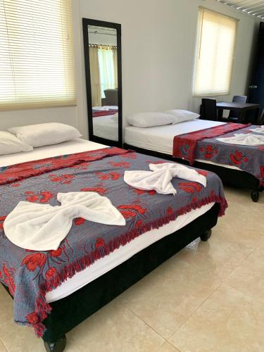 two beds in a room with towels on them at Casa Santiago Mayor in Cali