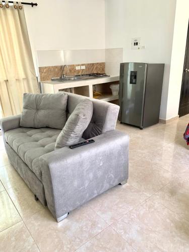 a couch in a living room with a kitchen at Casa Santiago Mayor in Cali