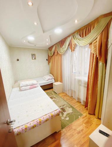 Habitación pequeña con 2 camas y ventana en Apartments Ahmetova 6 32 en Almaty