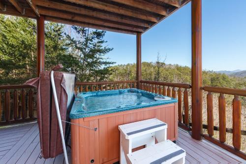 bañera de hidromasaje en la cubierta de una cabaña en Heavenly Vista at Crown Point cabin, en Sevierville