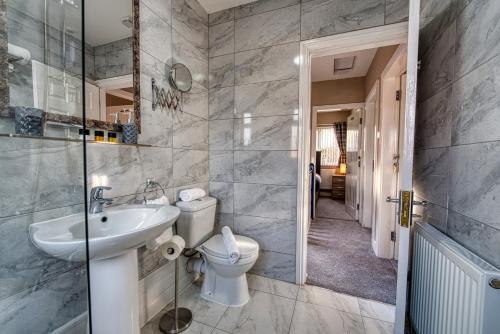 a bathroom with a toilet and a sink at Stylish House - B'ham Airport and NEC, JLR Solihull, Business & Leisure Stays - Aspen House in Solihull