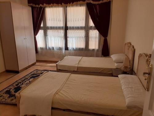 two beds in a room with a window at Small Friendly Apart In a Villa - New Cairo 5th Settlement in Cairo