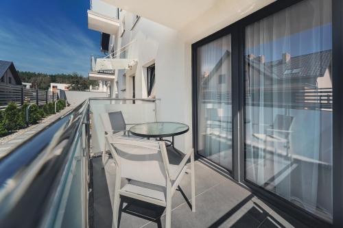 balkon ze szklanym stołem i krzesłami w obiekcie Marittimo Resort w Świnoujściu