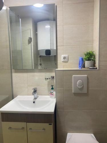 a bathroom with a sink and a mirror at Apartman KulTurista in Zlatibor